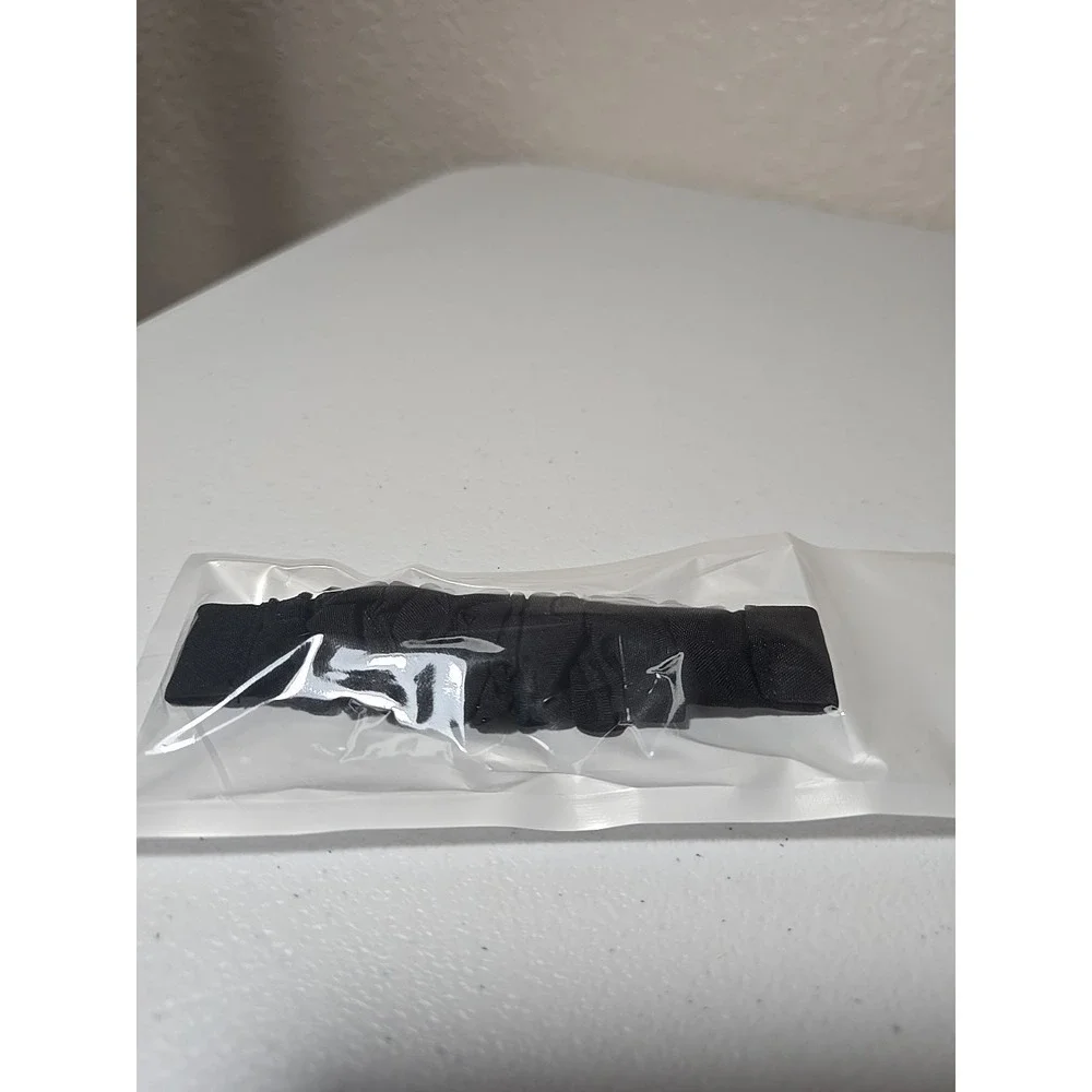 Scrunchie-style watch band for a fitness tracker, made of a black, ruched fabric